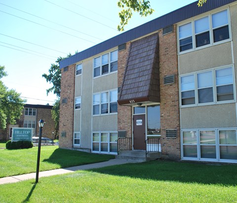 a brick building with a green lawn in front of it