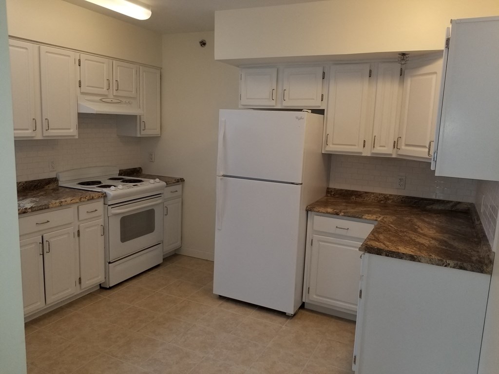a kitchen with white appliances and white cabinets