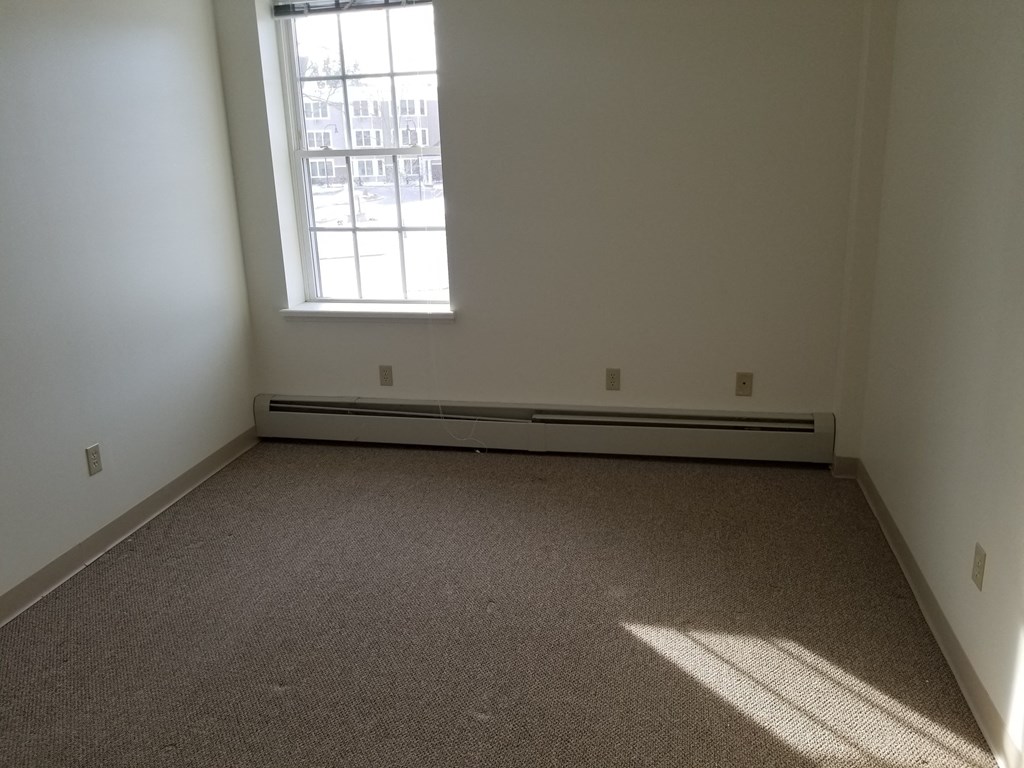 an empty room with carpet and a window
