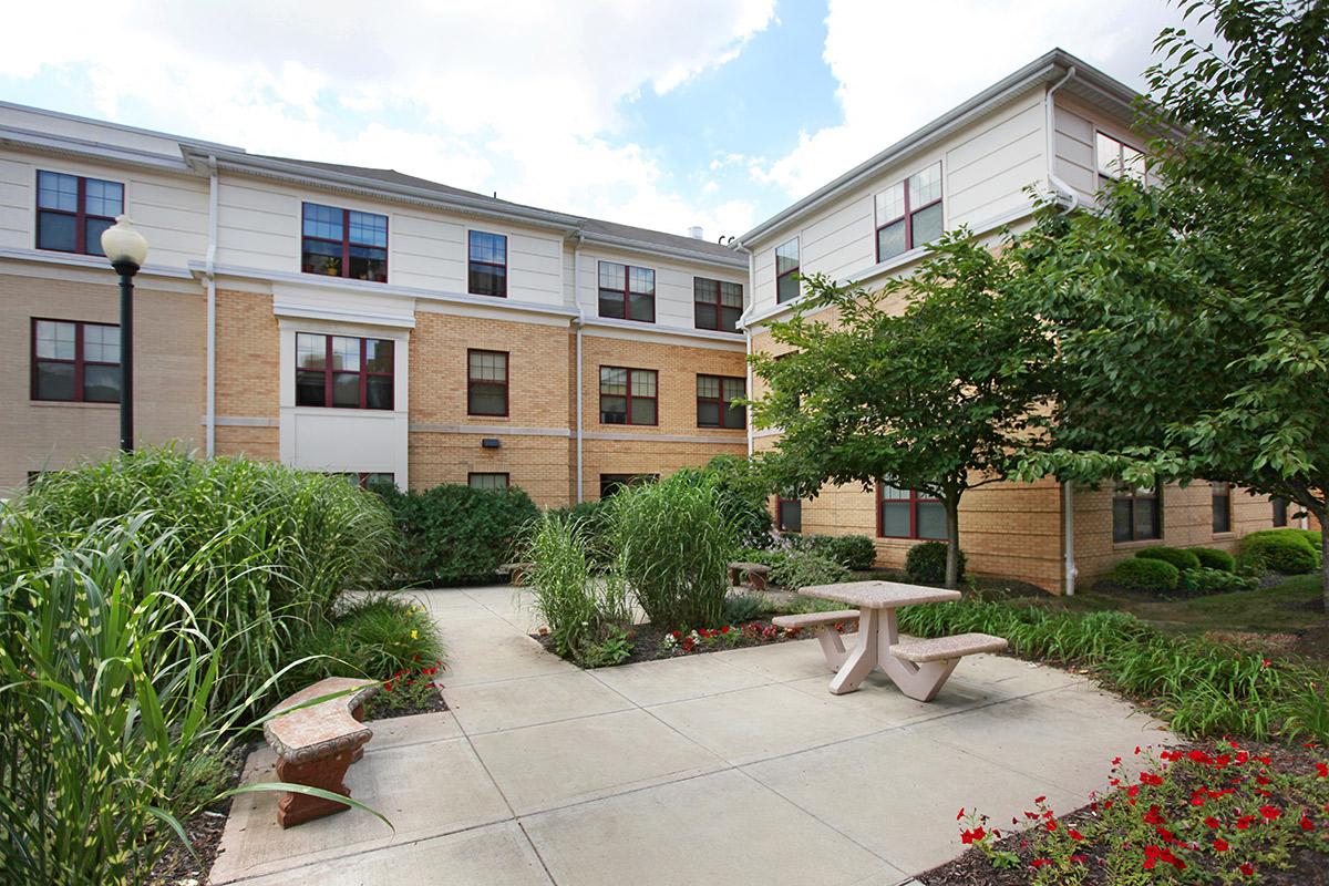 a courtyard with a table and benches in front of a building