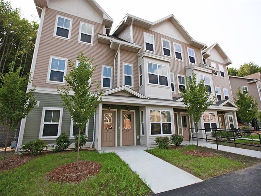 an apartment building with a sidewalk in front of it