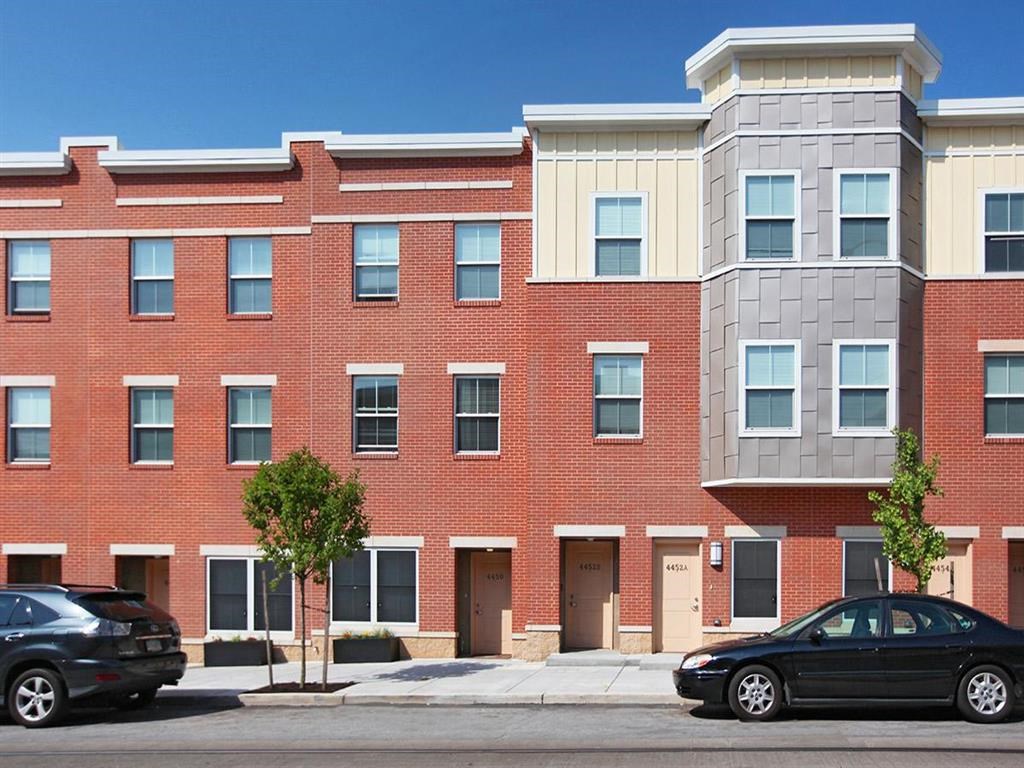 a brick building with two cars parked in front of it