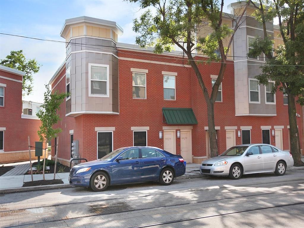 a red brick building with two cars parked in front of it