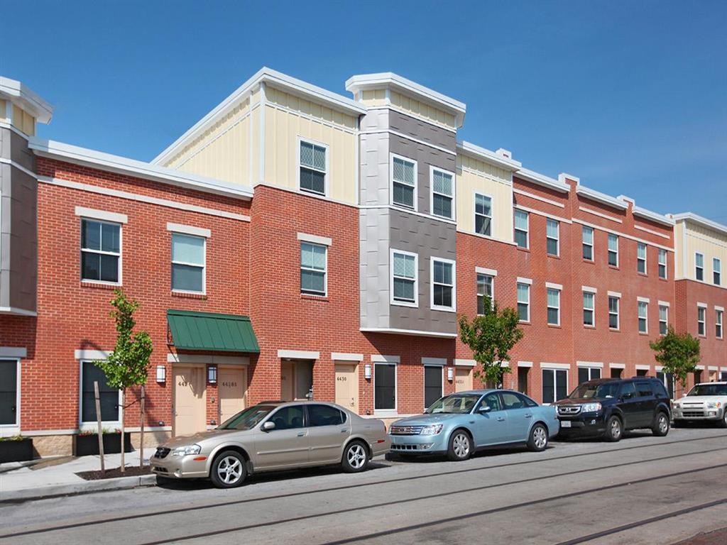 a city street with cars parked in front of a brick building