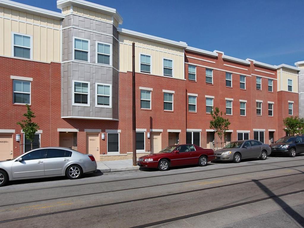 a city street with cars parked in front of a brick building