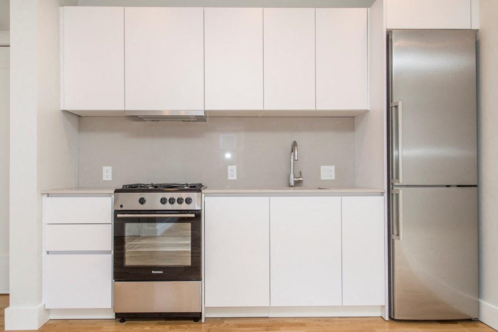 a white kitchen with stainless steel appliances and white cabinets