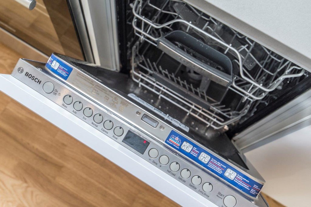 a close up of an open dishwasher with its door open