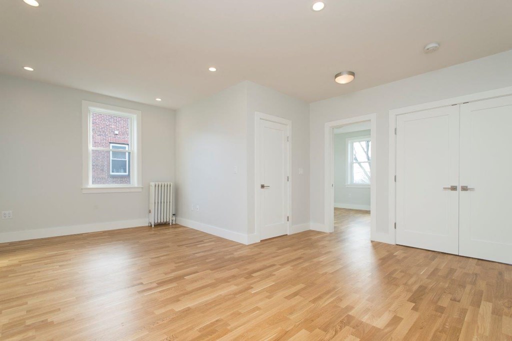 a living room with a hard wood floor and white walls
