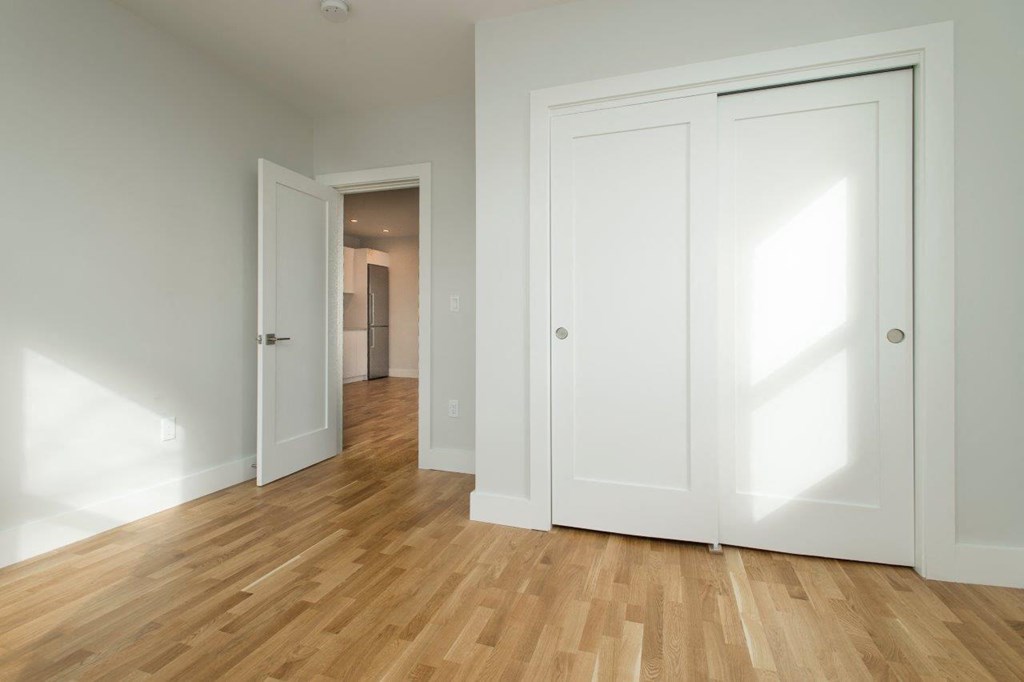 a room with two closets and a wood floor