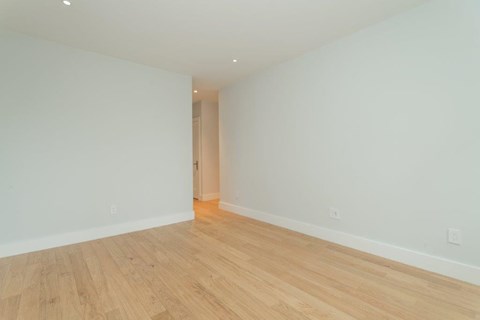 a living room with a wood floor and white walls