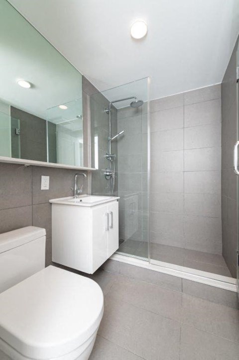 a white bathroom with a toilet and a shower