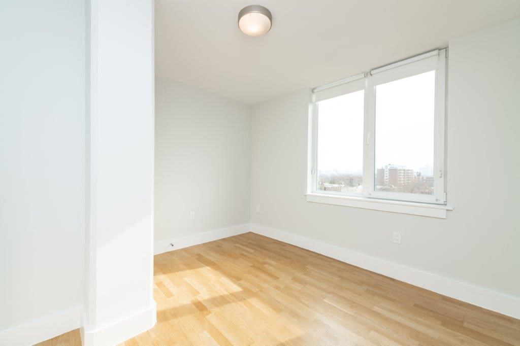 an empty room with a window and wooden floors