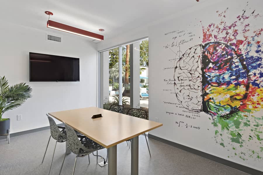 a conference room with a table and a painting on the wall