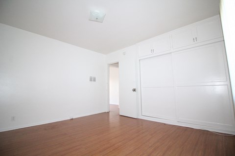 an empty room with white walls and a wood floor