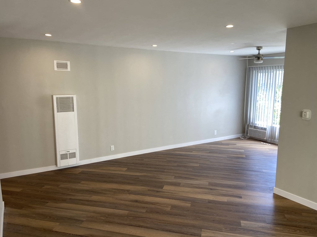 a renovated living room with wood floors and a window
