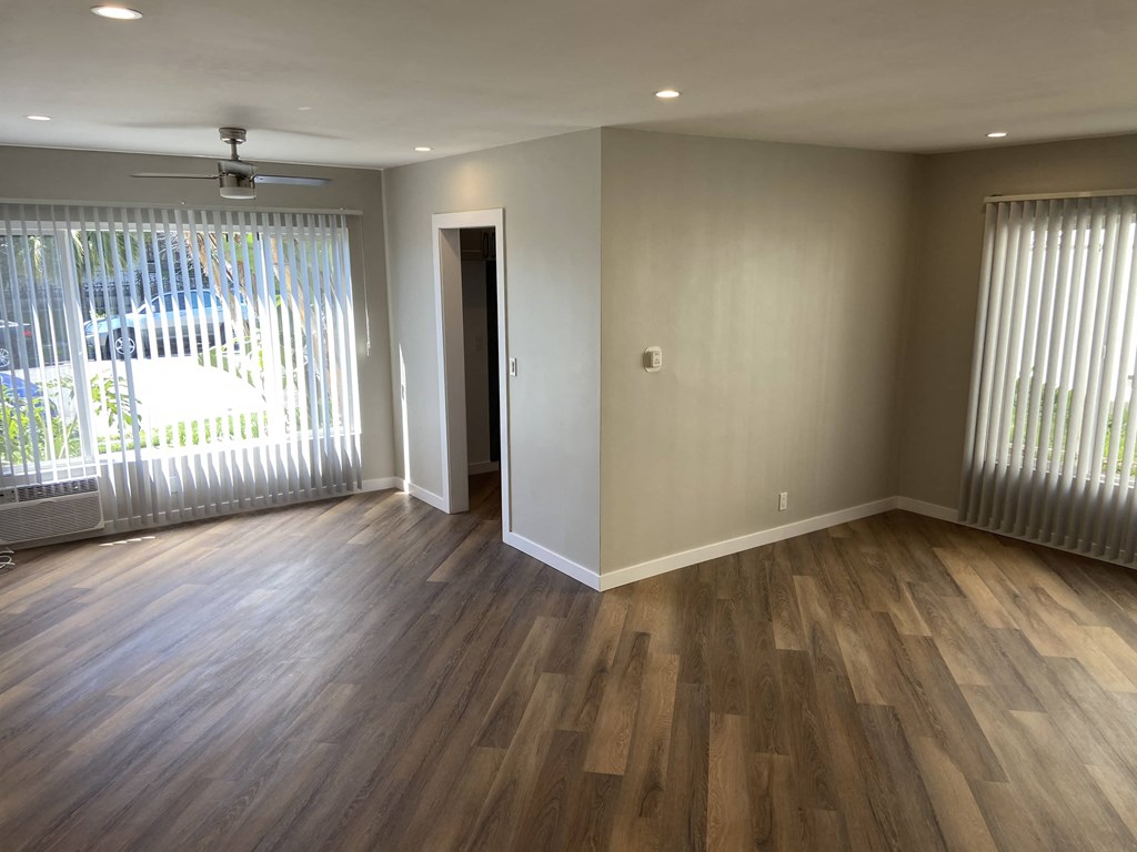 a living room with wood flooring and a large window