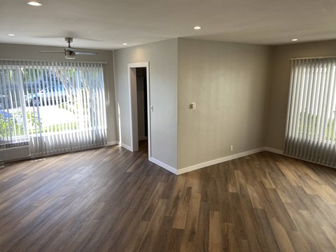a living room with wood flooring and a large window
