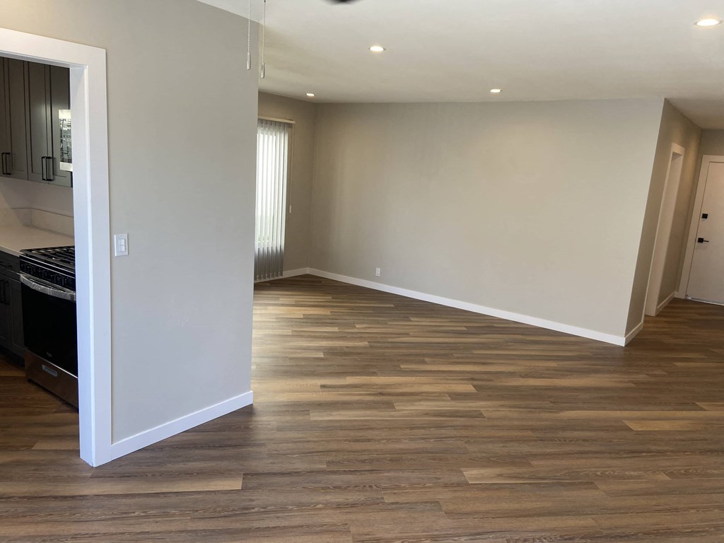 a renovated living room and kitchen with wood flooring