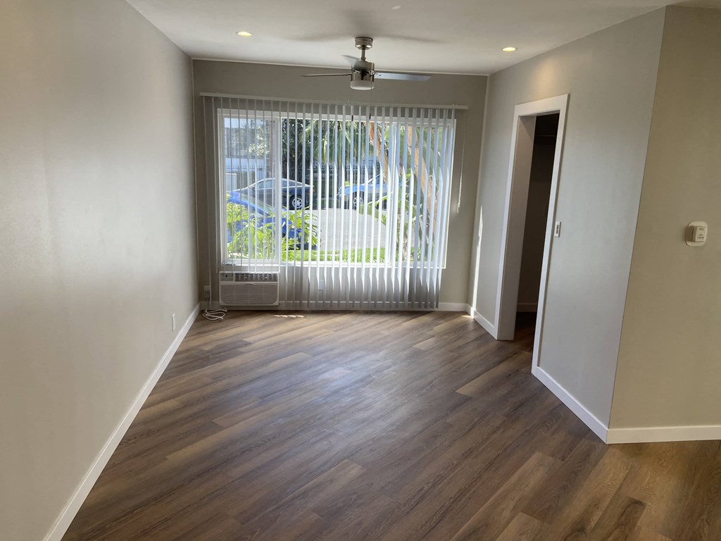 a living room with a large window and wooden floors