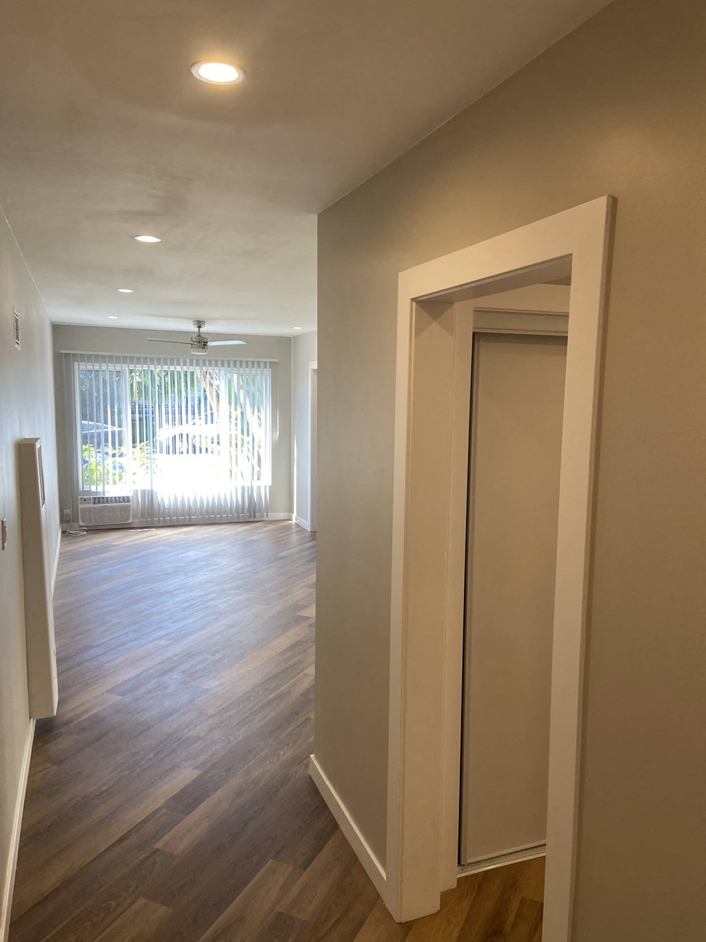 a renovated living room and dining room with wood flooring