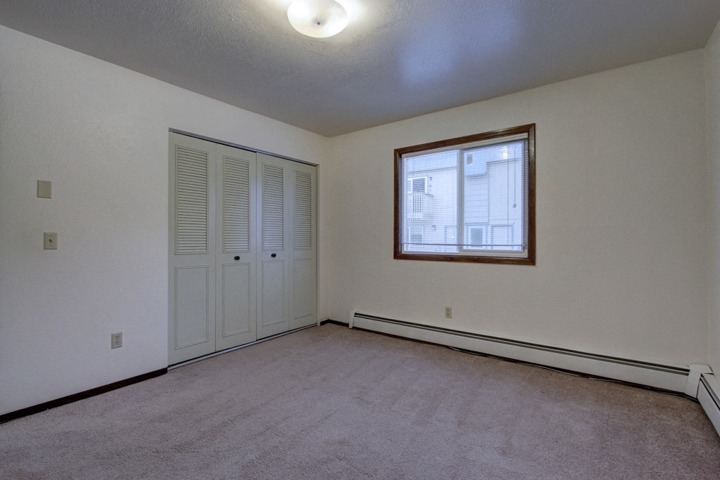 the living room of an empty house with white walls and a window