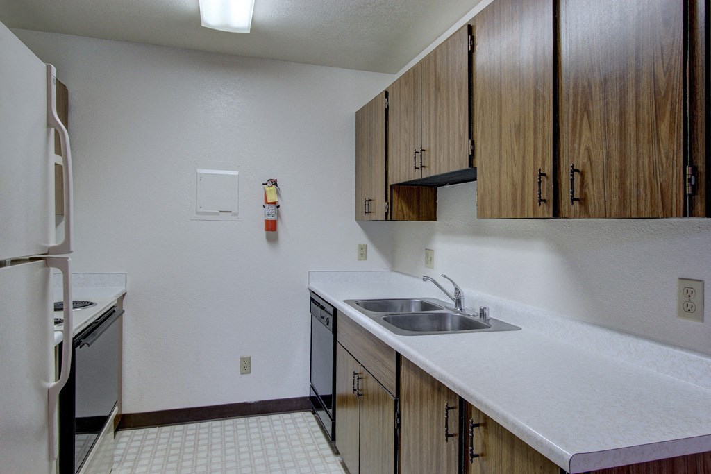 an empty kitchen with a sink and a refrigerator