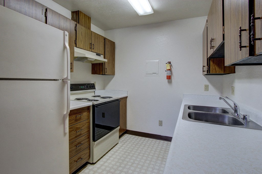 an empty kitchen with a sink and a refrigerator