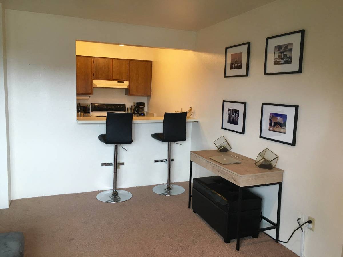 a small living room with a bar and a kitchen