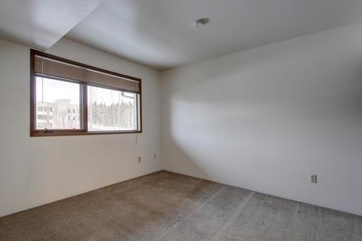 an empty room with a window and a tile floor