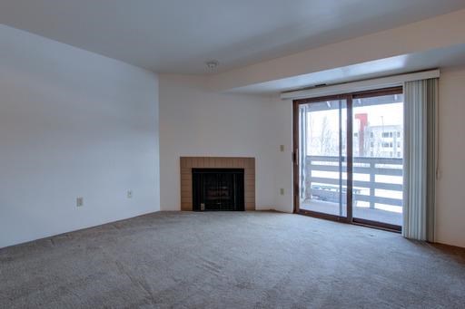 an empty living room with a fireplace and a glass door