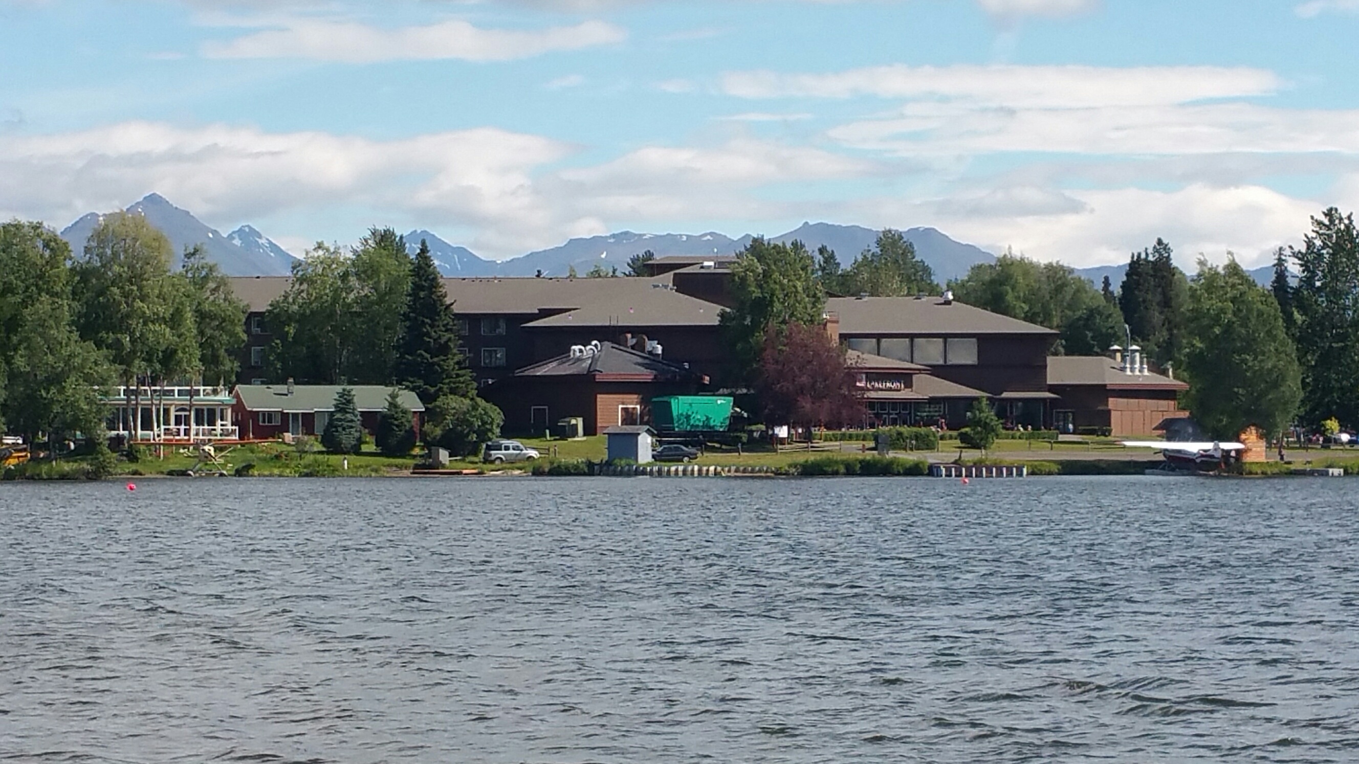 a lodge on a lake with mountains in the background
