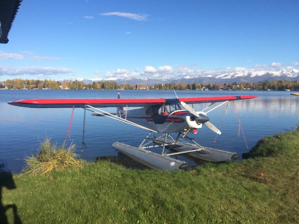 a small plane parked next to a lake