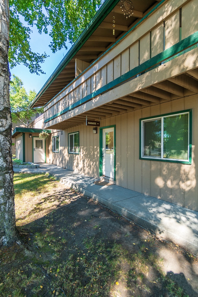 the front of a house with a porch and a sidewalk