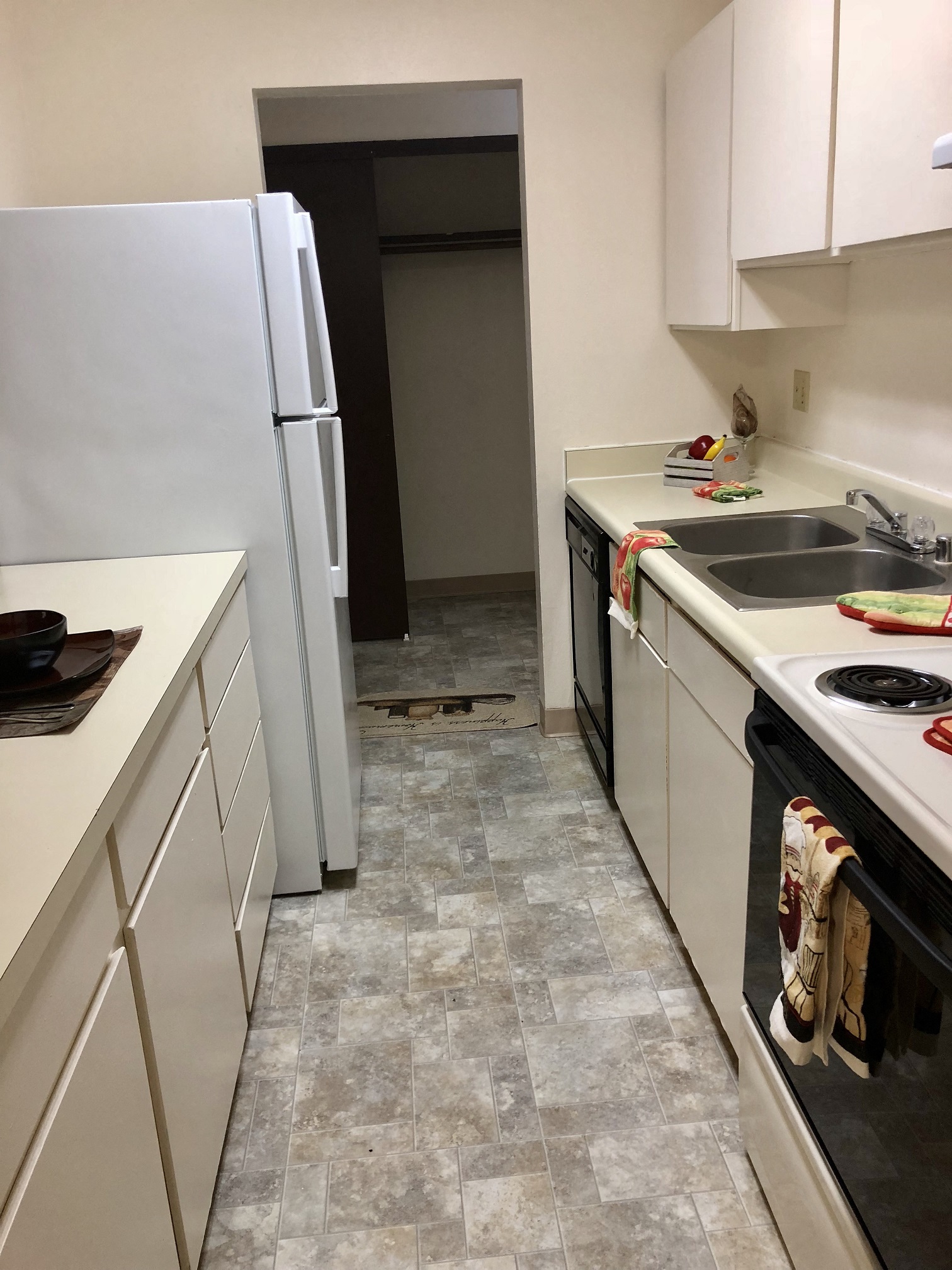 a kitchen with white cabinets and a sink and a refrigerator