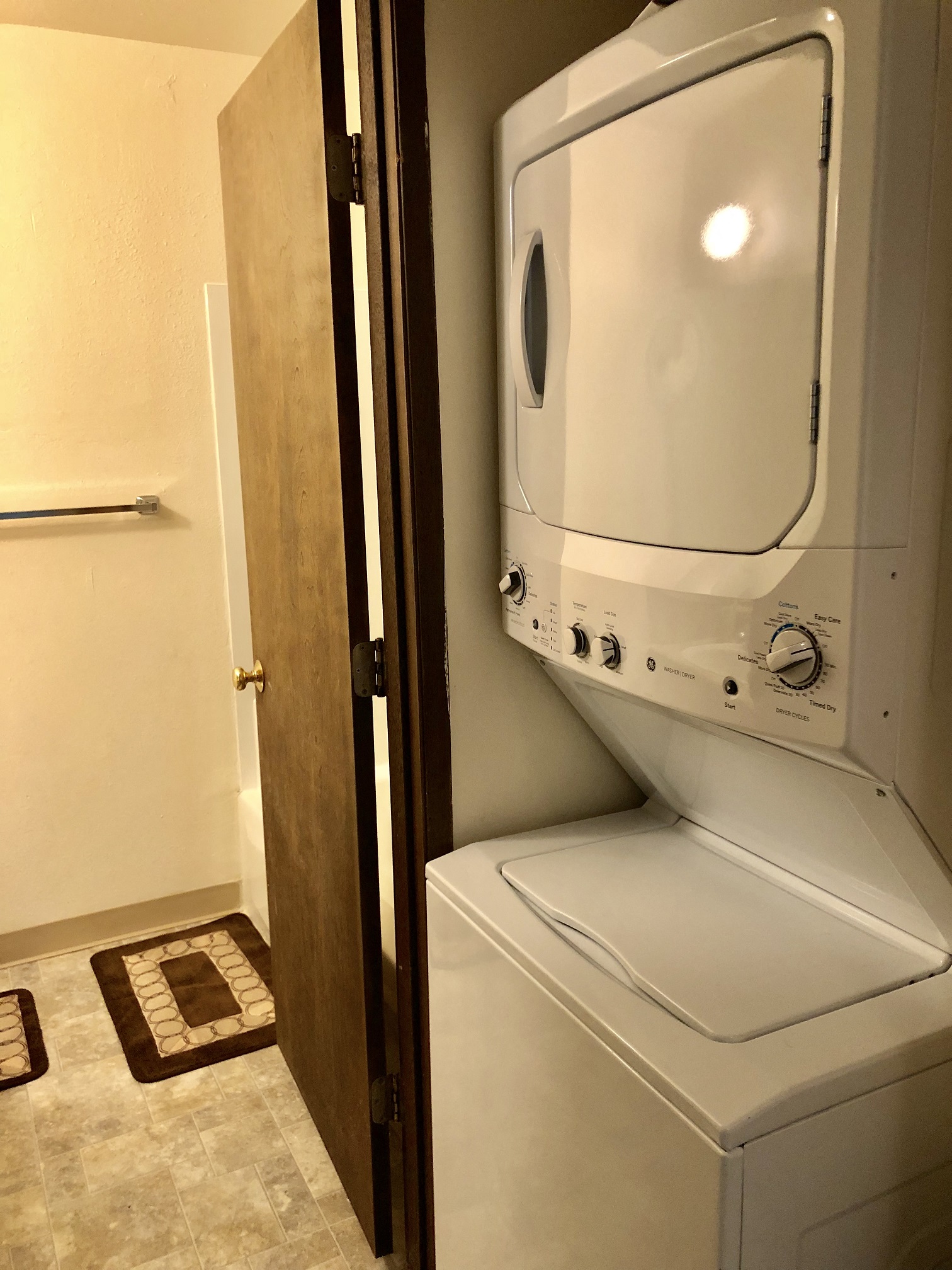 a white washer and dryer in a bathroom with a door