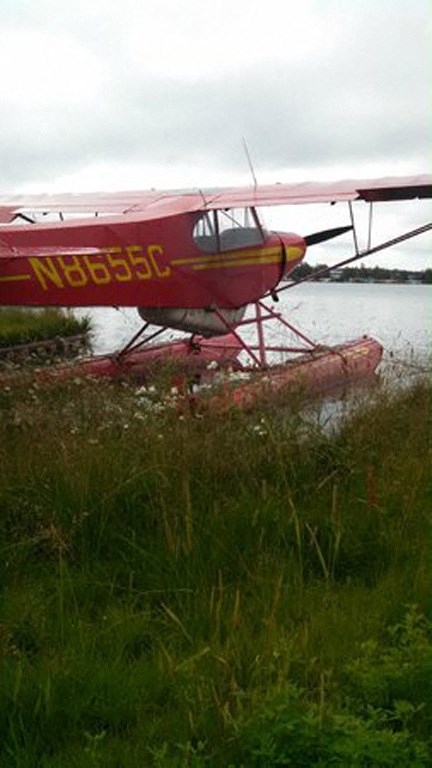 a red plane is sitting in the water