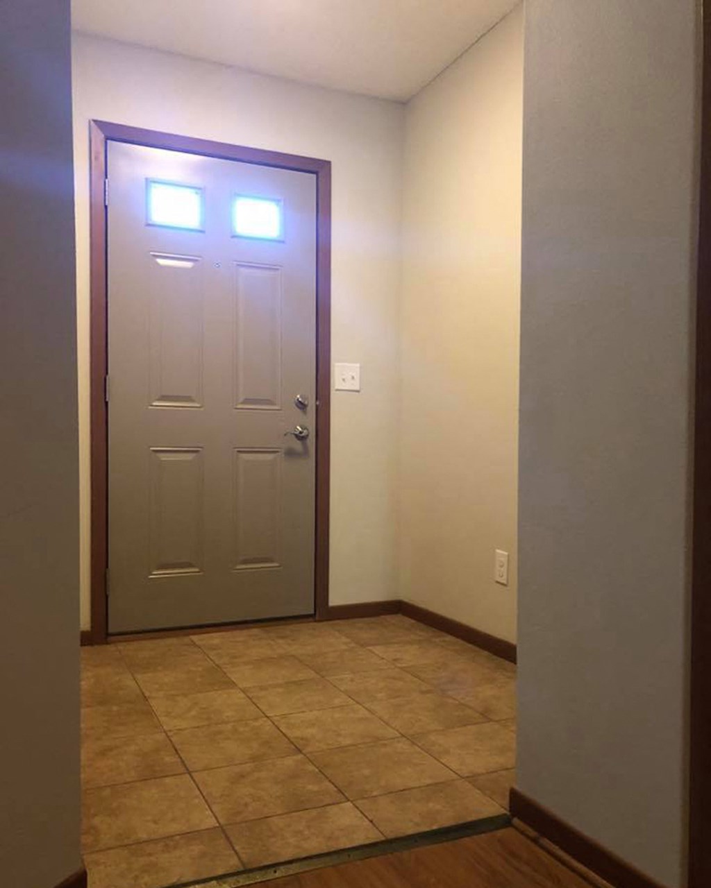 an empty room with a door and a tile floor