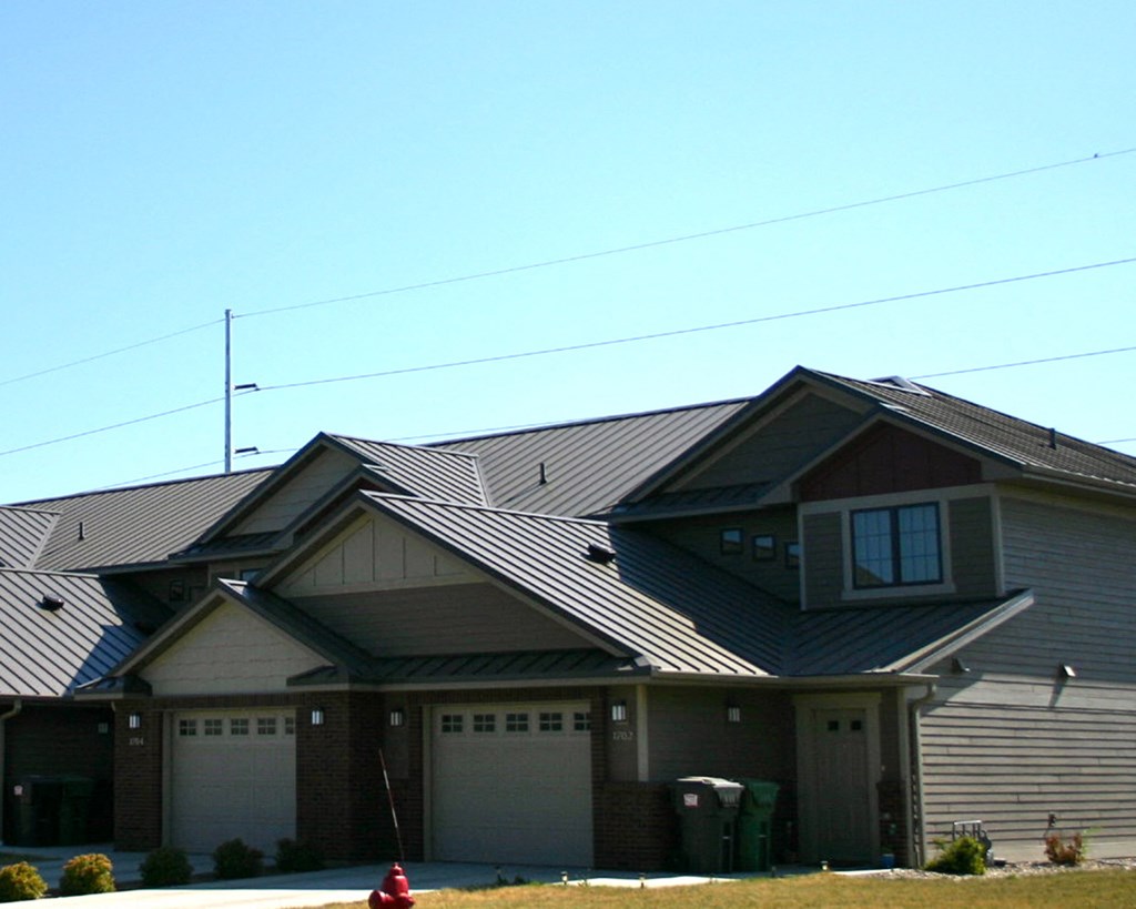 a house with a metal roof and garage doors