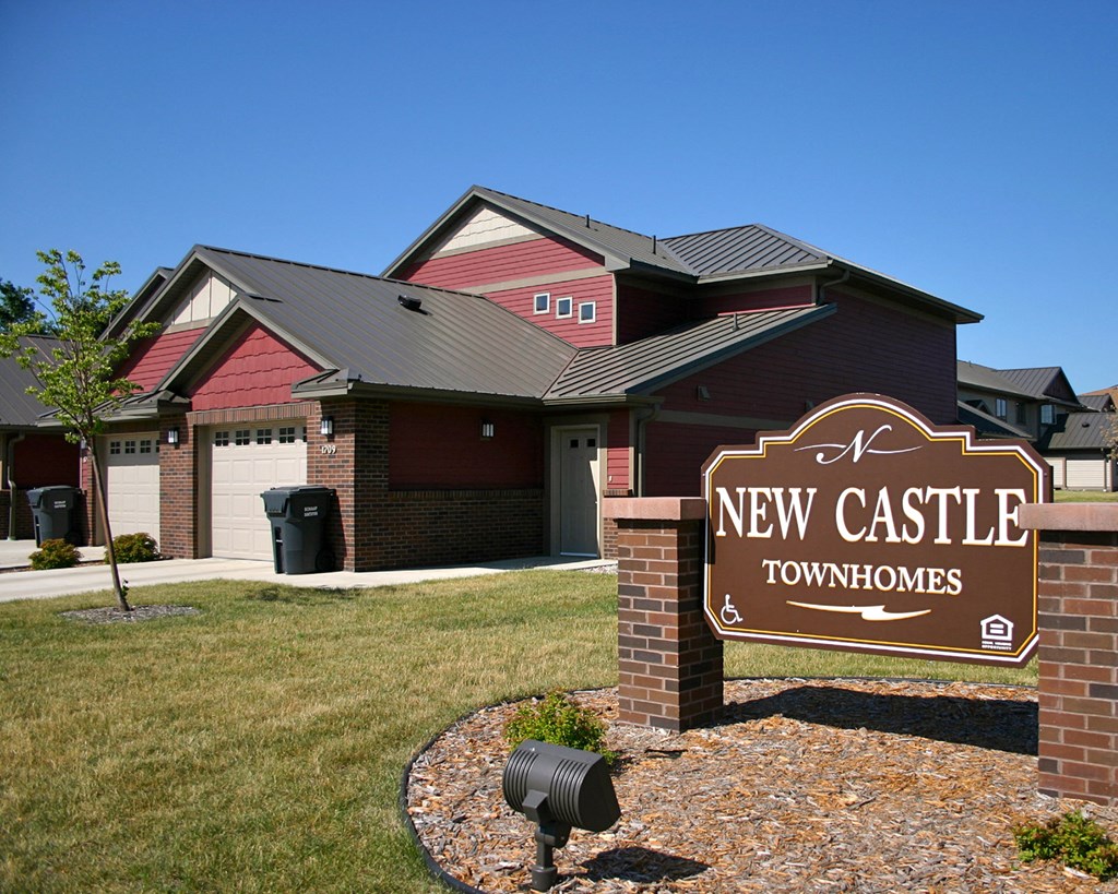 new castle townhomes sign in front of a house