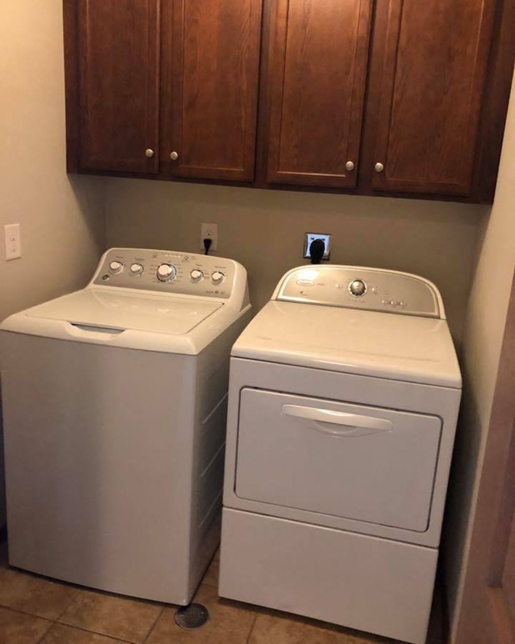 a washer and dryer in a room with wooden cabinets