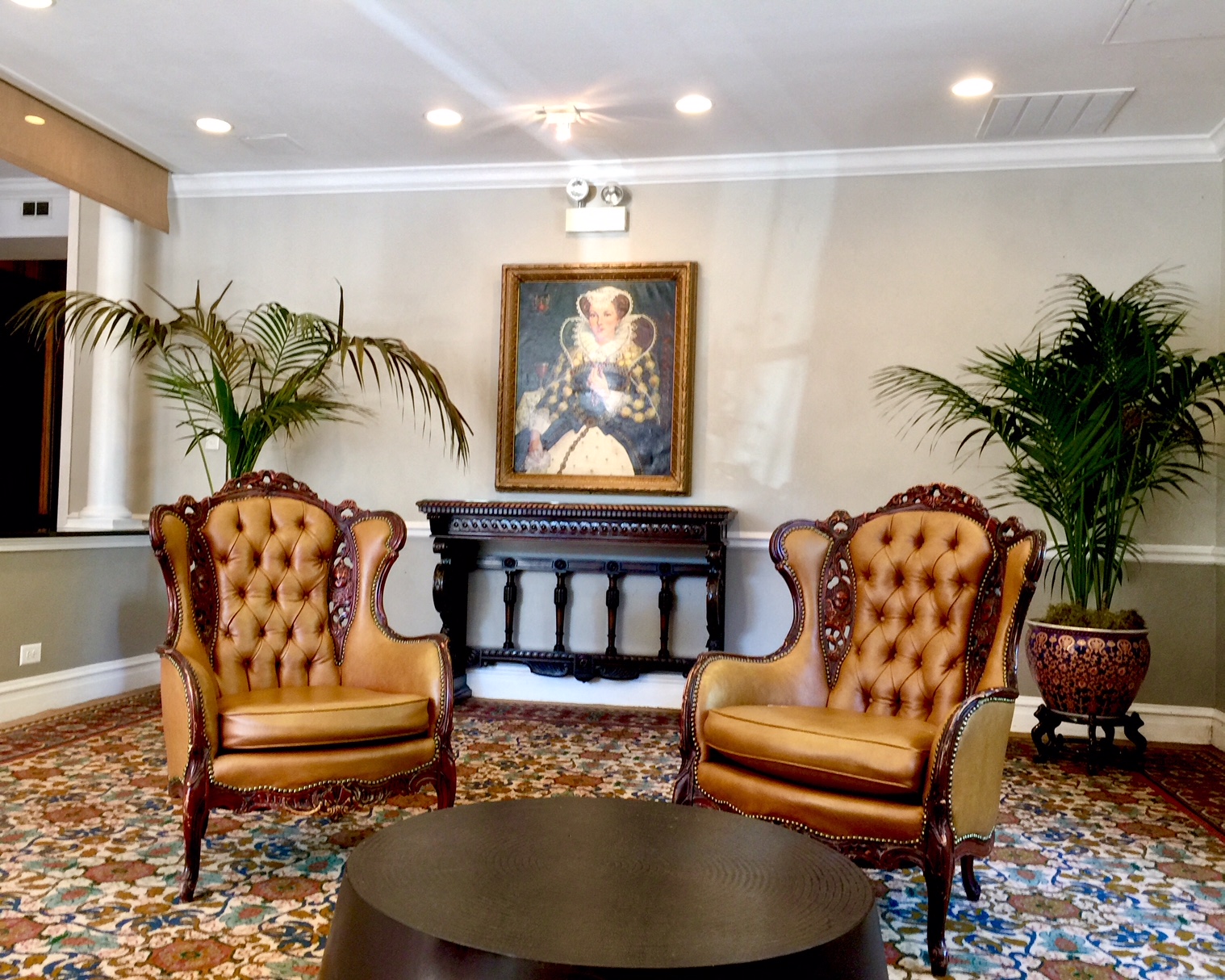 a room with two chairs and a table and a painting on the wall