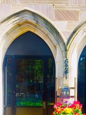 a vase with flowers in front of a building