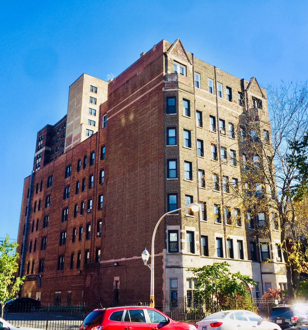 a tall brick building with cars parked in front of it