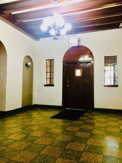 an empty room with a wooden door and a ceiling fan