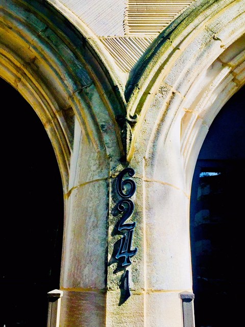 an old building with an arched window and a street sign on it