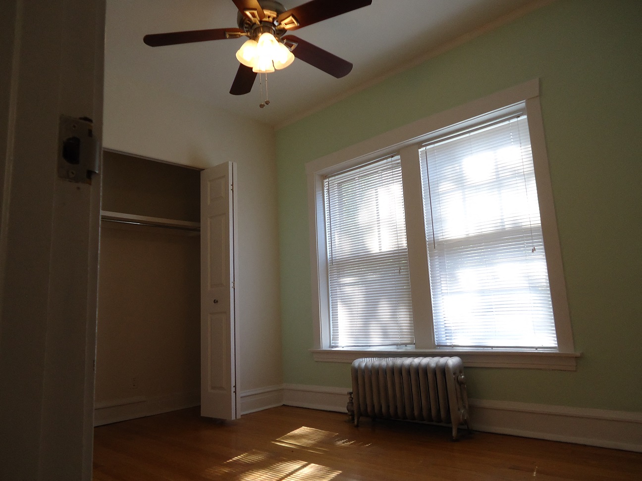 a large window in a room with a ceiling fan and a radiator