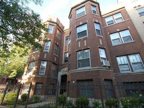 a tall brick building with a fence in front of it
