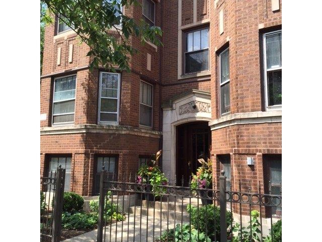a brick apartment building with a wrought iron fence
