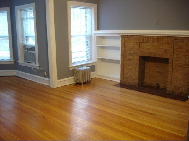 a living room with a fireplace and a wooden floor