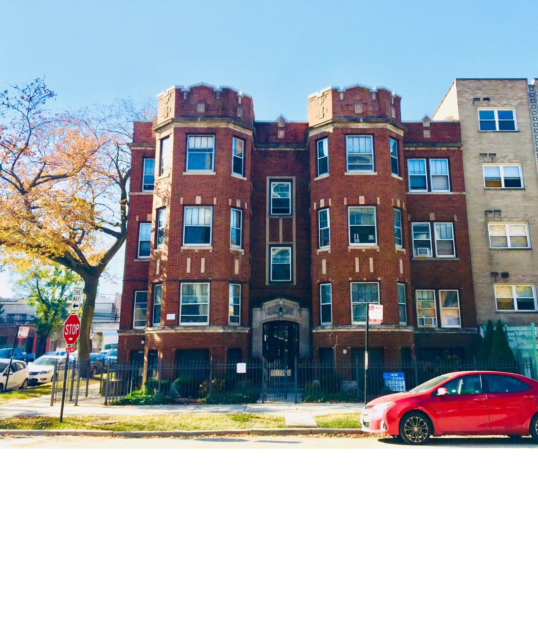a red car parked in front of a building